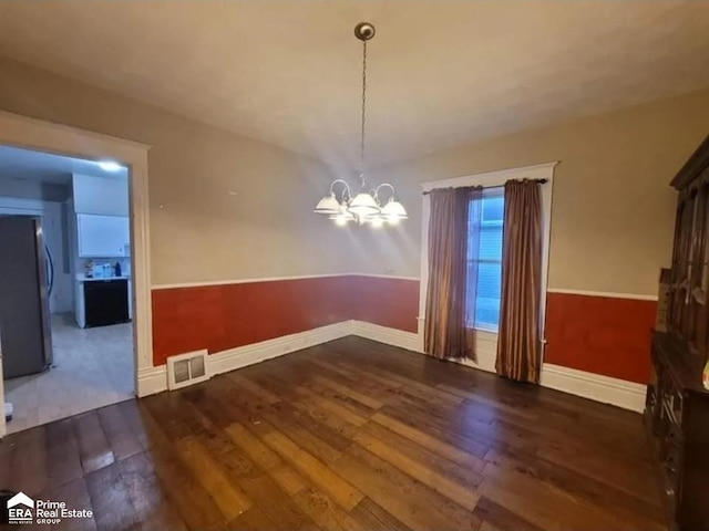 108 N Mercer St, Durand, MI 48429 - unfurnished dining area with hardwood / wood-style floors and a chandelier