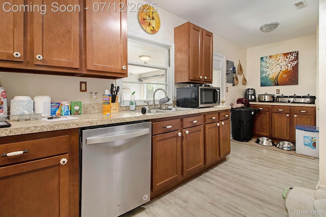 26651 Shiawassee Rd, Southfield, MI 48033 - kitchen featuring stainless steel appliances, brown cabinetry, light wood finished floors, and light countertops