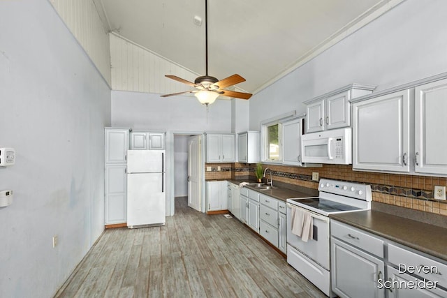 65 Sundago Park St, Hastings, MI 49058 - kitchen with white appliances, dark countertops, tasteful backsplash, high vaulted ceiling, and light wood-style flooring