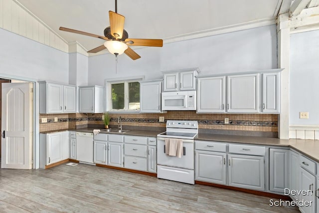 65 Sundago Park St, Hastings, MI 49058 - kitchen featuring white appliances, backsplash, dark countertops, ceiling fan, and light wood finished floors