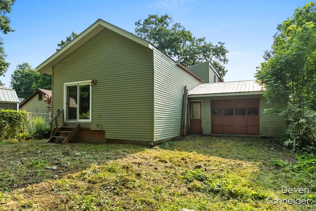 65 Sundago Park St, Hastings, MI 49058 - rear view of property featuring entry steps, a garage, and an outbuilding
