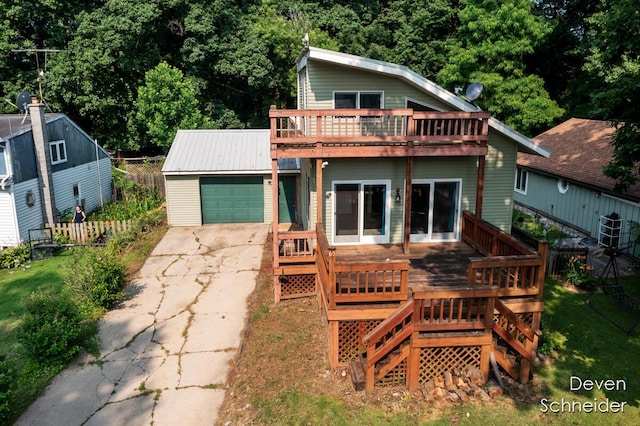65 Sundago Park St, Hastings, MI 49058 - rear view of house with concrete driveway, an outbuilding, an attached garage, a deck, and stairs