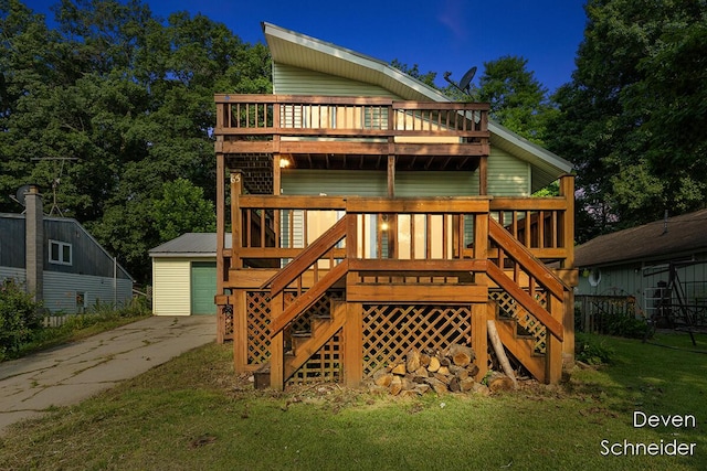 65 Sundago Park St, Hastings, MI 49058 - back of house featuring stairs, a lawn, a wooden deck, a detached garage, and an outbuilding