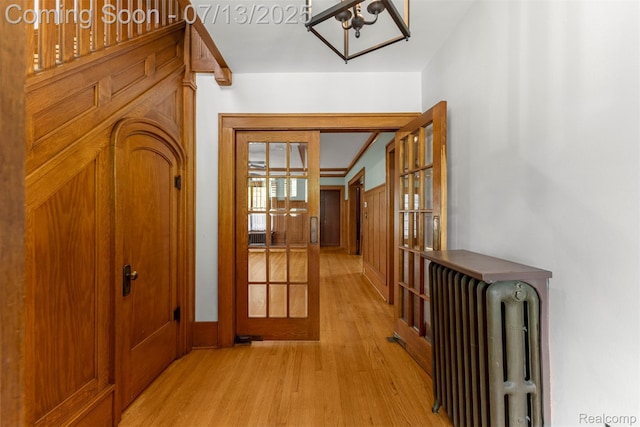 830 S Brady Rd, Dearborn, MI 48124 - corridor with french doors, radiator heating unit, light wood-style flooring, and a chandelier