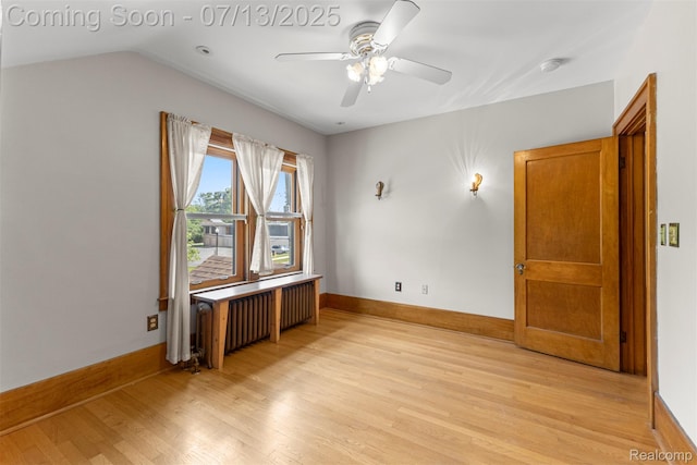 830 S Brady Rd, Dearborn, MI 48124 - empty room with light wood-style floors, ceiling fan, radiator heating unit, a smoke detector, and vaulted ceiling