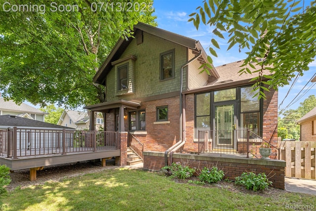830 S Brady Rd, Dearborn, MI 48124 - rear view of house with brick siding, a yard, a deck, and a sunroom