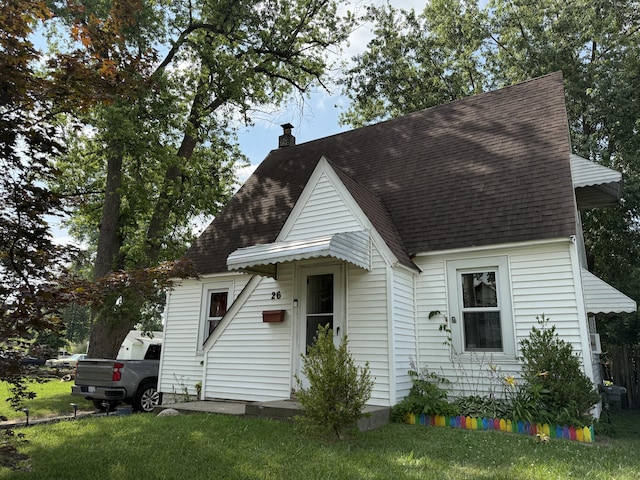 26 Edna Ave, Pontiac, MI 48341 - view of front of house featuring a shingled roof, a front lawn, and a chimney