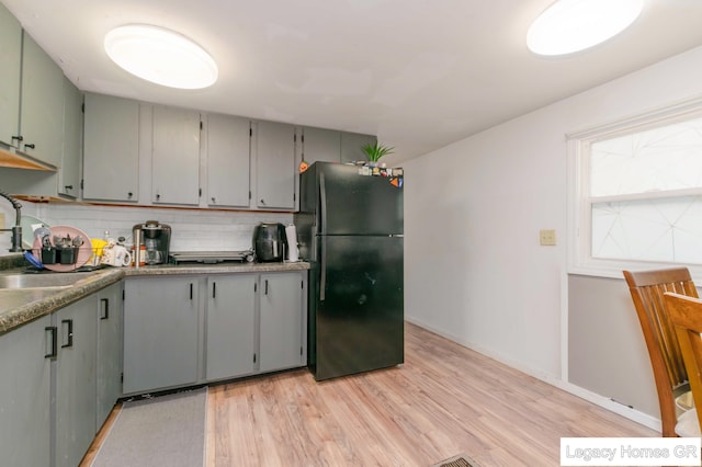 961 Dolphin St SW Unit 013, Wyoming, MI 49509 - kitchen with freestanding refrigerator, light wood-type flooring, decorative backsplash, and gray cabinetry