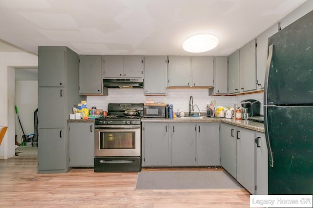 961 Dolphin St SW Unit 013, Wyoming, MI 49509 - kitchen with black appliances, under cabinet range hood, decorative backsplash, and light wood-style flooring
