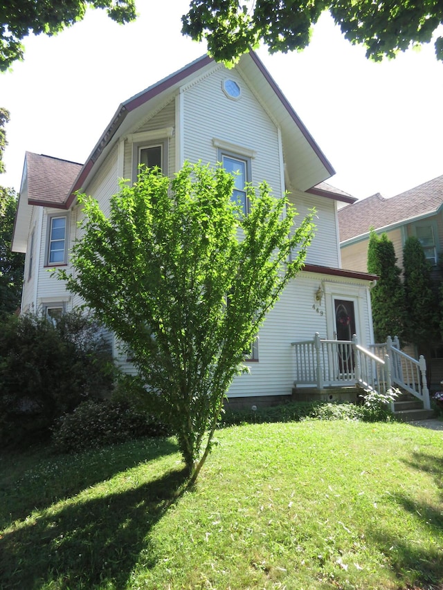 449 4th St, Manistee, MI 49660 - rear view of property featuring a lawn