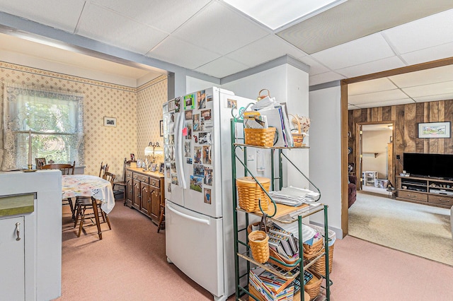 449 4th St, Manistee, MI 49660 - kitchen featuring carpet, freestanding refrigerator, a paneled ceiling, and wooden walls