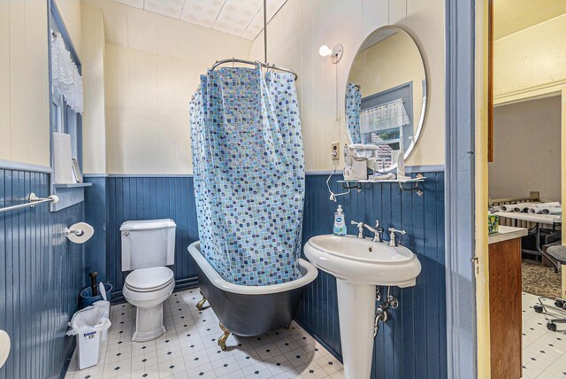 449 4th St, Manistee, MI 49660 - full bath featuring wainscoting, a freestanding bath, tile patterned floors, and curtained shower