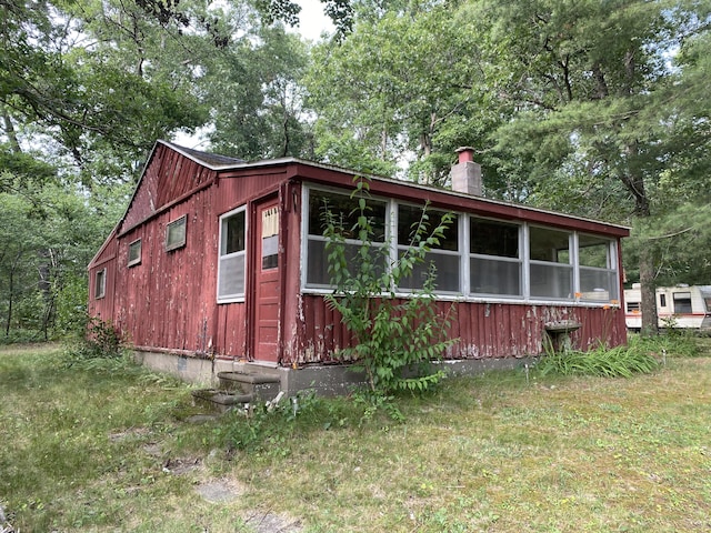 2031 E Oak St, Newaygo, MI 49337 - view of side of property with a chimney and view of wooded area