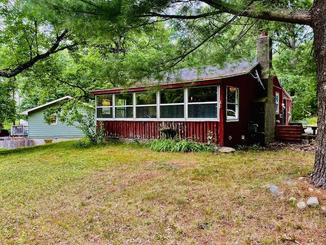 2031 E Oak St, Newaygo, MI 49337 - view of front of home with a chimney, a front lawn, and a sunroom