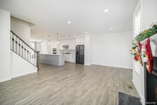 2965 Aughton Rd, Ann Arbor, MI 48105 - unfurnished living room featuring light wood-style flooring, recessed lighting, and stairway
