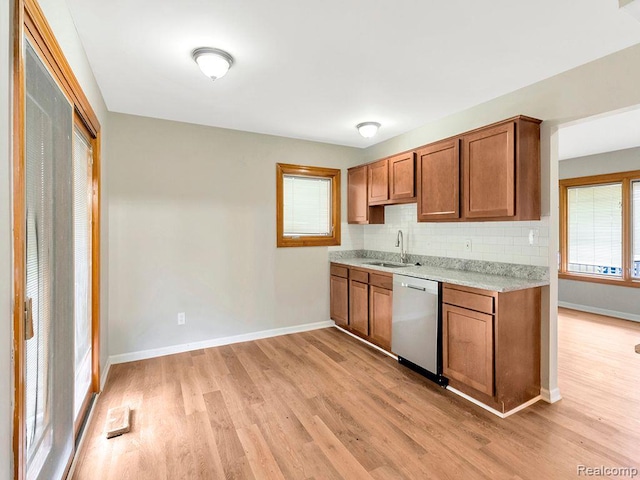 33855 Cherry Hill Rd, Westland, MI 48186 - kitchen with stainless steel dishwasher, light wood-style flooring, brown cabinets, and backsplash
