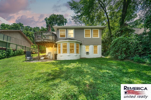 9420 Van Antwerp Rd, Brighton, MI 48116 - back of house at dusk with a patio area, a yard, stucco siding, and a wooden deck