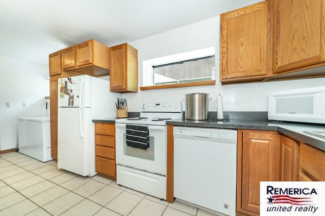 9420 Van Antwerp Rd, Brighton, MI 48116 - kitchen featuring white appliances, dark countertops, light tile patterned flooring, and brown cabinetry