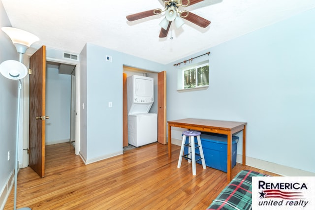 9420 Van Antwerp Rd, Brighton, MI 48116 - unfurnished bedroom with stacked washer and clothes dryer, light wood-type flooring, and ceiling fan