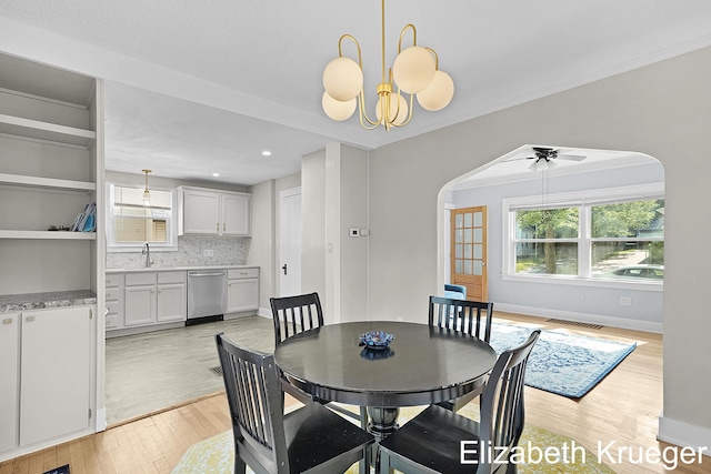 1215 Emerald Ave NE, Grand Rapids, MI 49505 - dining space featuring arched walkways, light wood-style flooring, plenty of natural light, a chandelier, and recessed lighting