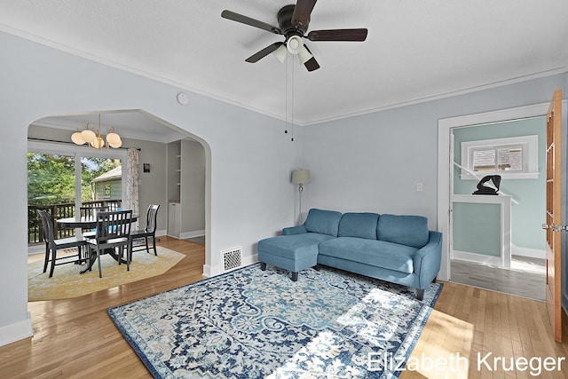 1215 Emerald Ave NE, Grand Rapids, MI 49505 - living area with arched walkways, crown molding, a chandelier, a ceiling fan, and light wood-style flooring