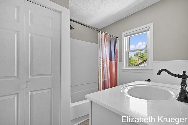 1215 Emerald Ave NE, Grand Rapids, MI 49505 - full bath featuring shower / bathtub combination with curtain, vanity, a textured ceiling, a closet, and a wainscoted wall