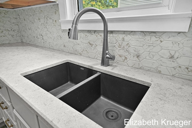 1215 Emerald Ave NE, Grand Rapids, MI 49505 - kitchen view of decorative backsplash, light stone counters, and white cabinetry