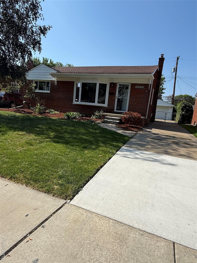 19612 Gaukler St, Saint Clair Shores, MI 48080 - single story home with brick siding, an outdoor structure, a front yard, and a chimney