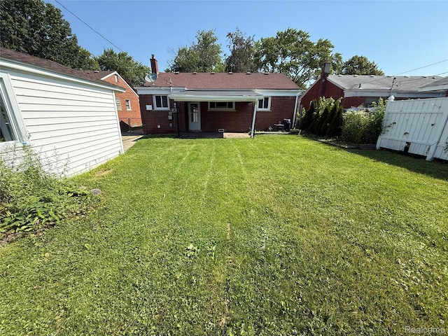 19612 Gaukler St, Saint Clair Shores, MI 48080 - back of house with a yard, a chimney, and brick siding