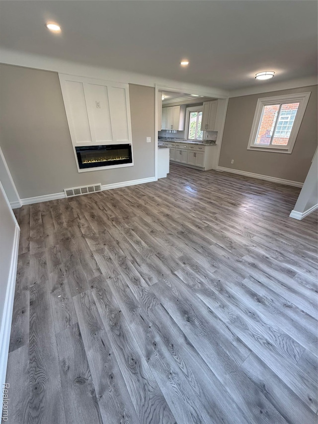 19612 Gaukler St, Saint Clair Shores, MI 48080 - unfurnished living room with dark wood-type flooring, a glass covered fireplace, and recessed lighting