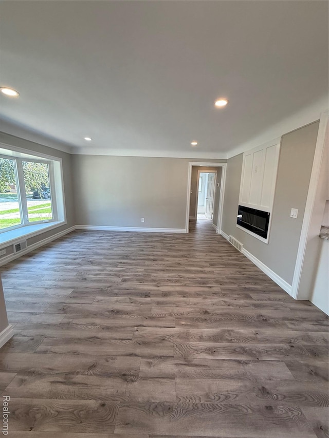 19612 Gaukler St, Saint Clair Shores, MI 48080 - unfurnished living room with dark wood-type flooring, recessed lighting, and a glass covered fireplace
