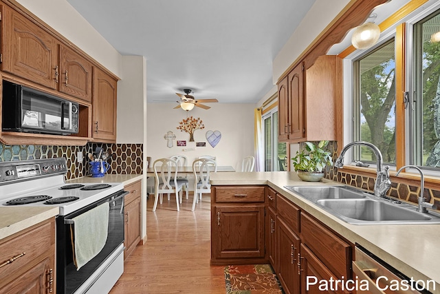 4707 Cannonsburg Rd NE, Belmont, MI 49306 - kitchen with white electric stove, black microwave, light countertops, backsplash, and ceiling fan