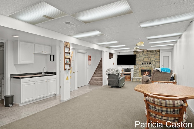 4707 Cannonsburg Rd NE, Belmont, MI 49306 - living area with wet bar, a stone fireplace, a ceiling fan, stairway, and light tile patterned floors