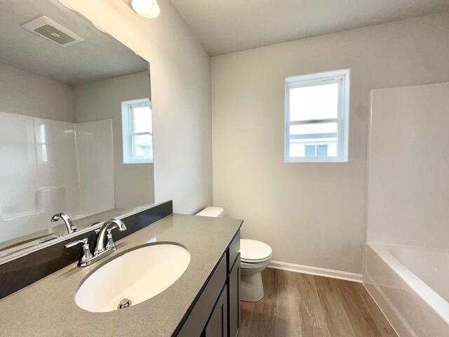 LOT100 Wren Dr SE, Caledonia, MI 49316 - bathroom with vanity, wood finished floors, and shower / washtub combination