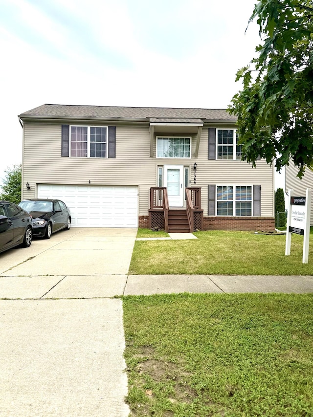 7366 Maplelawn Dr, Ypsilanti, MI 48197 - split foyer home with a garage, driveway, a front yard, and brick siding