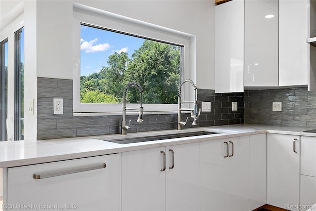 6727 Napier Rd, Plymouth, MI 48170 - kitchen featuring white cabinets, light countertops, backsplash, and modern cabinets
