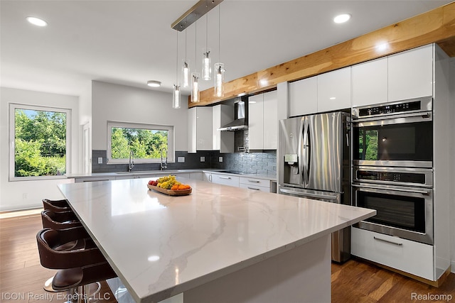 6727 Napier Rd, Plymouth, MI 48170 - kitchen with appliances with stainless steel finishes, wall chimney range hood, recessed lighting, backsplash, and white cabinetry