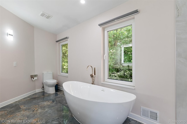 6727 Napier Rd, Plymouth, MI 48170 - bathroom featuring a freestanding bath, plenty of natural light, and marble tiled flooring
