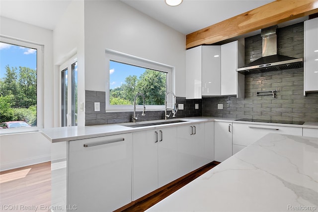 6727 Napier Rd, Plymouth, MI 48170 - kitchen with wall chimney exhaust hood, black electric stovetop, white cabinetry, and plenty of natural light