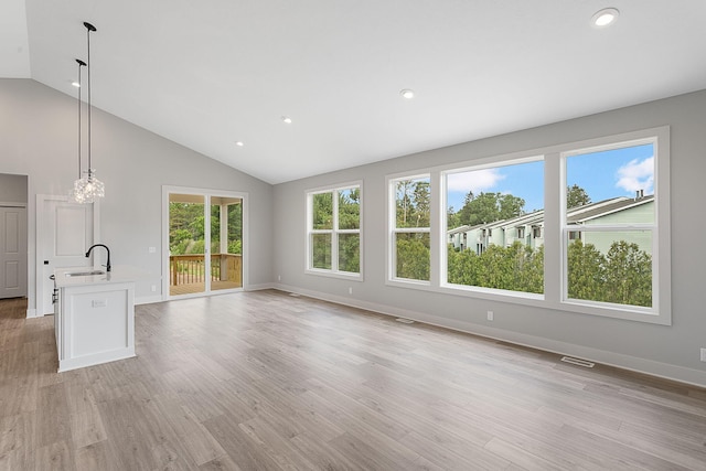 6153 Lake Wind Ave, Holland, MI 49423 - unfurnished living room with recessed lighting, light wood-style floors, high vaulted ceiling, and a chandelier