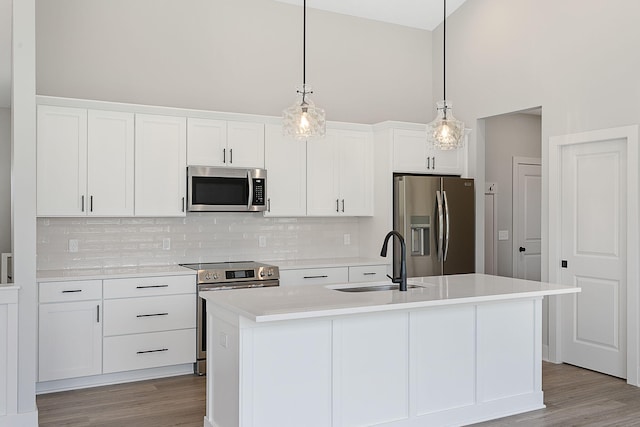 6153 Lake Wind Ave, Holland, MI 49423 - kitchen with appliances with stainless steel finishes, decorative backsplash, white cabinetry, light countertops, and a towering ceiling