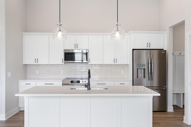 6153 Lake Wind Ave, Holland, MI 49423 - kitchen featuring stainless steel appliances, dark wood-style flooring, light countertops, white cabinets, and a towering ceiling