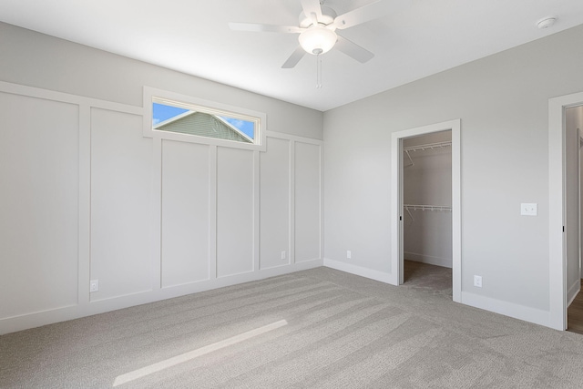 6153 Lake Wind Ave, Holland, MI 49423 - unfurnished bedroom with carpet, a spacious closet, ceiling fan, and a decorative wall