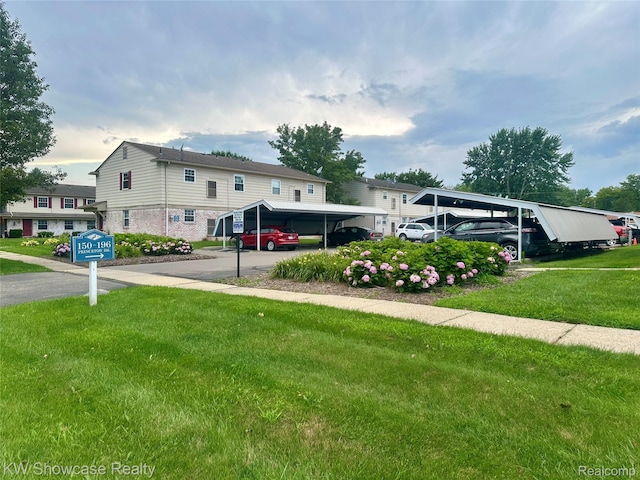 150 Princeton Dr Unit 22, South Lyon, MI 48178 - traditional home featuring a front yard, brick siding, and a carport