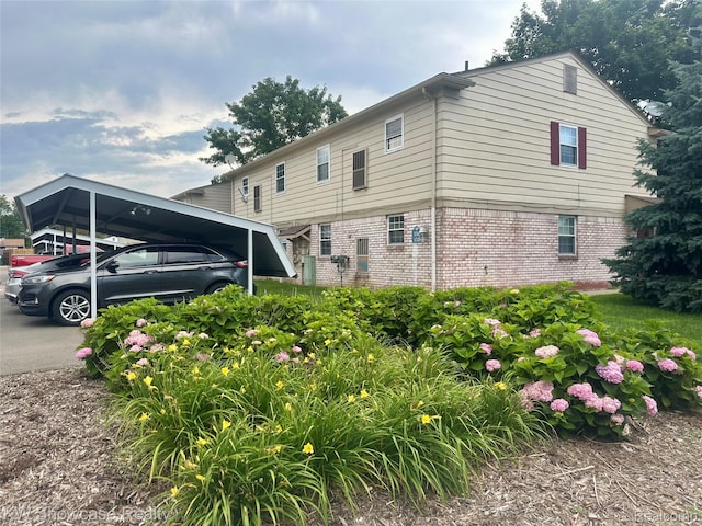 150 Princeton Dr Unit 22, South Lyon, MI 48178 - view of side of property with brick siding and a carport