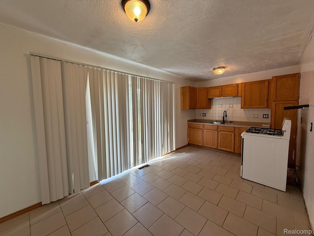 13420 Couwlier Ave, Warren, MI 48089 - kitchen with white gas range, a textured ceiling, brown cabinetry, light countertops, and backsplash