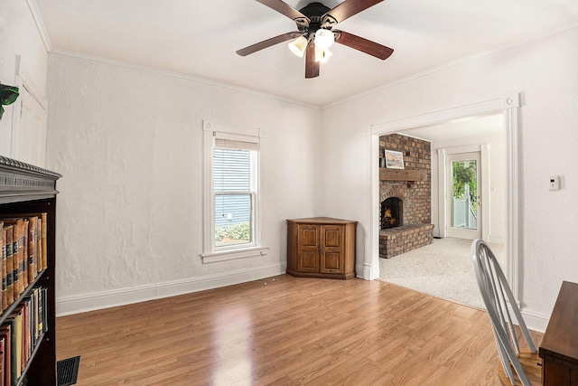 722 Conger St, South Haven, MI 49090 - unfurnished living room featuring a brick fireplace, light wood-style floors, a ceiling fan, and ornamental molding