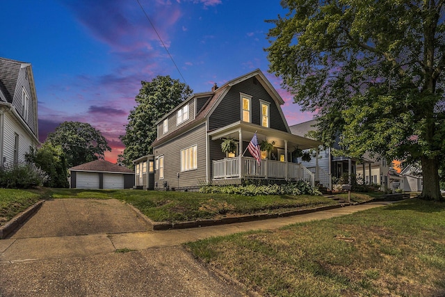 722 Conger St, South Haven, MI 49090 - view of front of property with a porch, an outdoor structure, a detached garage, a gambrel roof, and a lawn