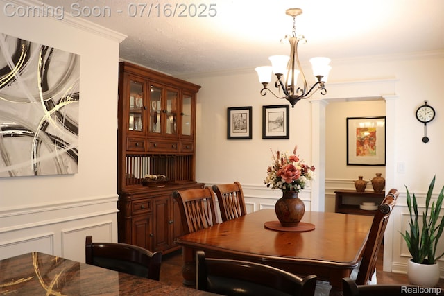 46877 W Ann Arbor Trl, Plymouth, MI 48170 - dining area featuring a decorative wall, a chandelier, ornamental molding, and wainscoting