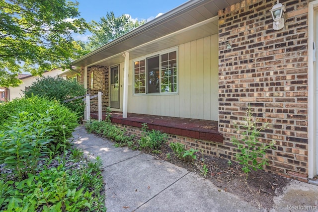 609 N Wickshire Ln, Durand, MI 48429 - view of exterior entry featuring a porch and brick siding